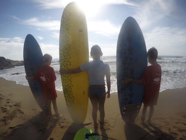  三个小家伙拿着冲浪板 